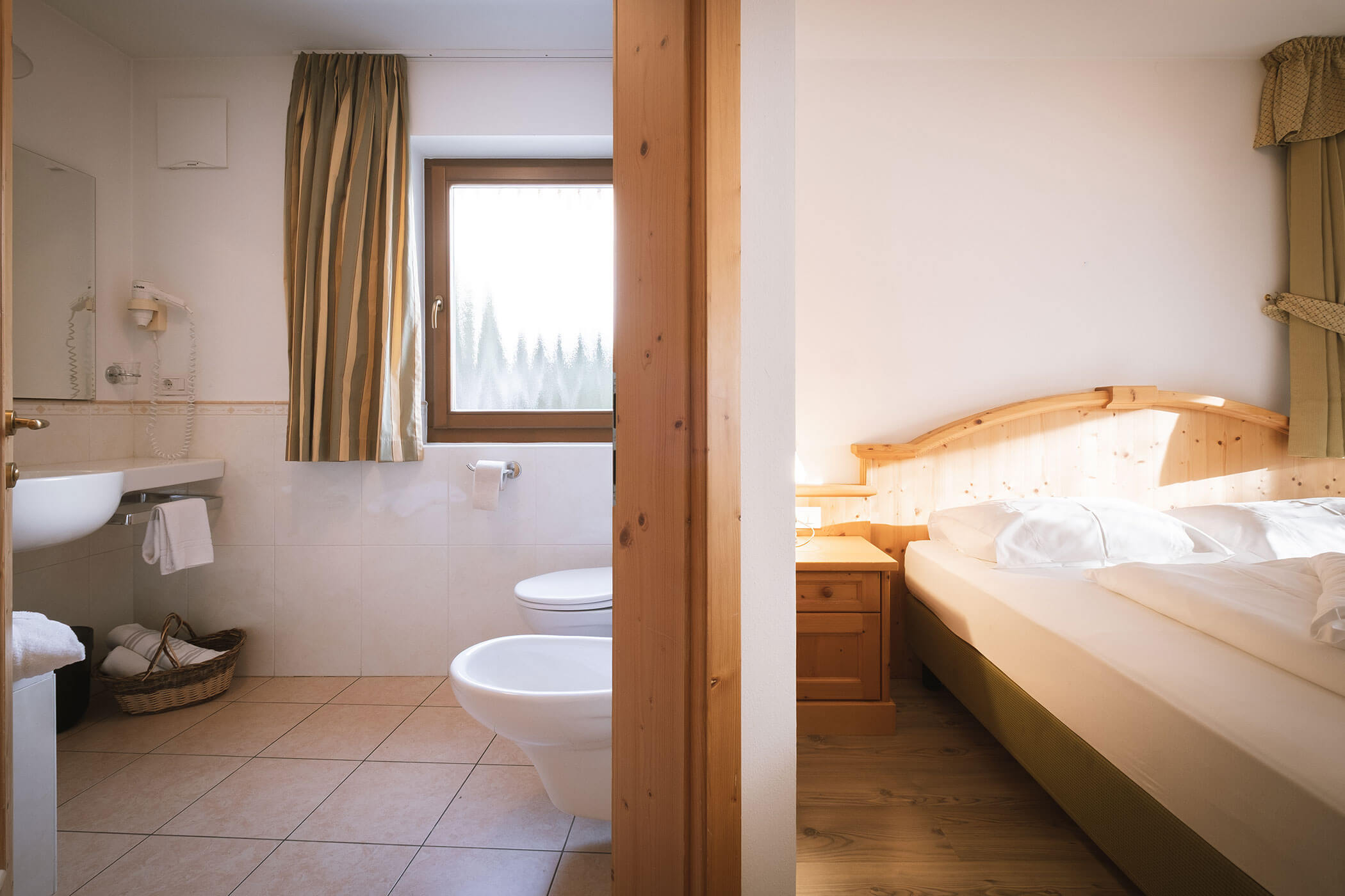 Accogliente camera d'albergo con letto matrimoniale e bagno privato con lavandino, WC e bidet. - Hotel Innerhofer