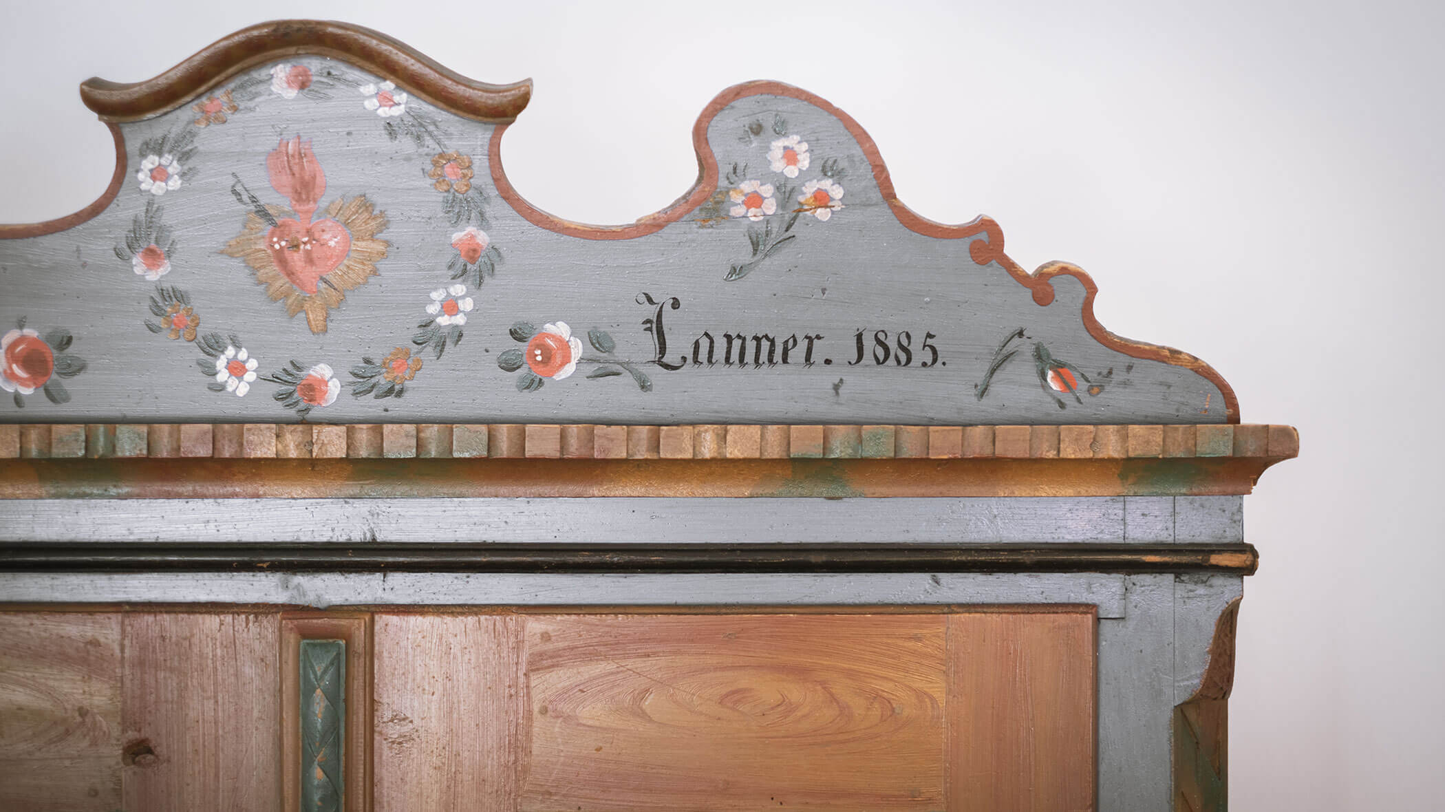 Decorative wooden cabinet top with floral paintings and the inscription Lanner. 1885. - Hotel Innerhofer